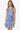 Woman wearing a blue floral dress on a white background