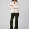 Front view of Joe’s Jeans Inez Corduroy Bootcut Pant in Olive showing mid-rise waist and full-length fit with a cream sherpa zip up jacket.