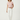 Woman wearing a pink top and white pants on a white background