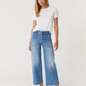 woman in white tee with button fly wide leg jeans on a white background