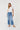 woman in white tee with button fly wide leg jeans on a white background