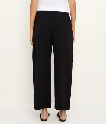 Person wearing black wide-leg pants on a white background