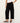 Person wearing black wide-leg pants on a white background