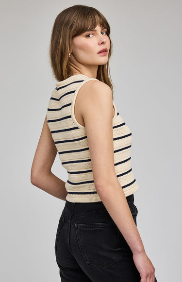 Woman wearing a striped sleeveless top against a plain background
