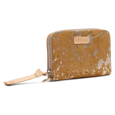 A zip-around wallet in a distressed tan leather finish with a paint-splatter pattern, featuring a light tan leather brand tab on the front and a matching wristlet strap.