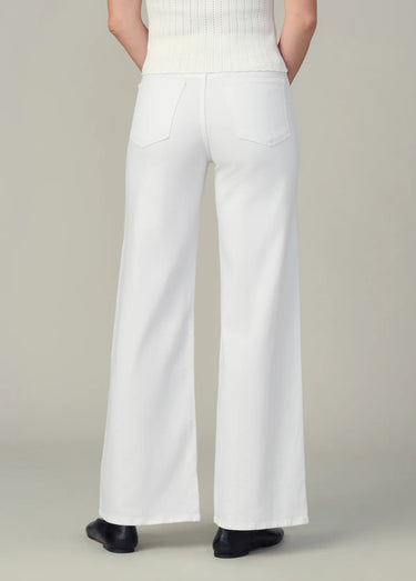 White pants worn by a person on a plain background