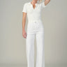 Woman wearing a white outfit against a plain background