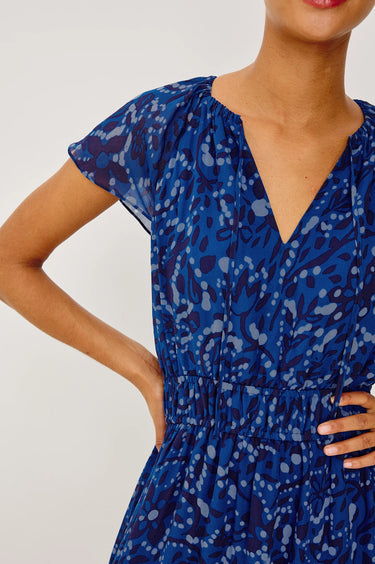 Woman wearing a blue floral dress against a white background
