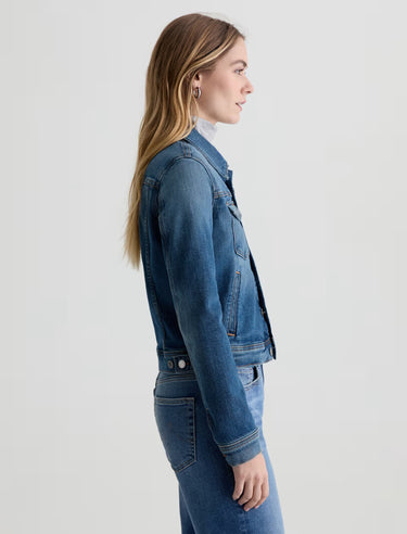 Woman wearing a blue denim jacket on a light gray background