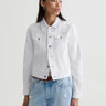 Person wearing a white denim jacket and light blue jeans on a plain background