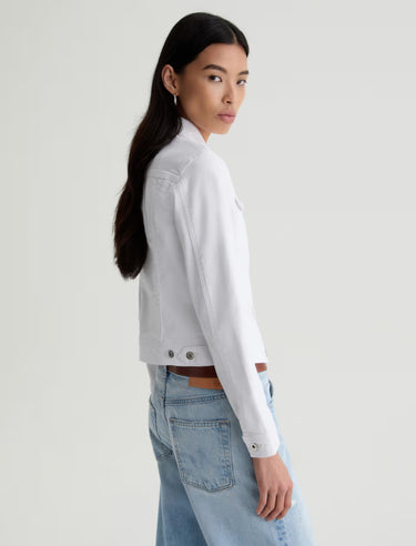 Woman wearing a white shirt and blue jeans on a plain background