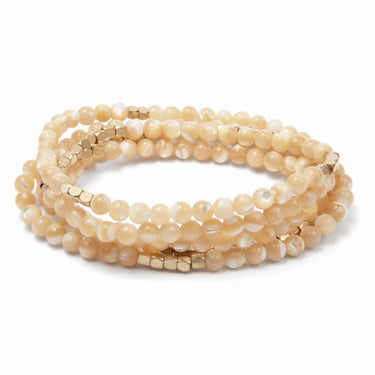 Set of beige beaded bracelets on a white background