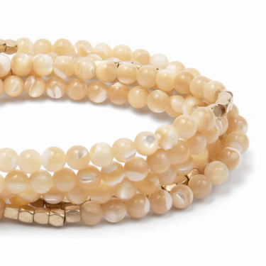 Set of beige beaded bracelets on a white background