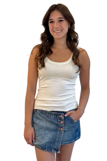 Woman wearing a pearl tank top and denim skirt on a white background