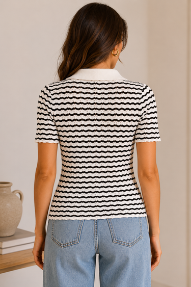 Person wearing a black and white striped shirt with a plain background