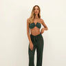 Close-up of a person wearing sheer emerald green wide-leg beach pants with a tie-front knot at the waist.